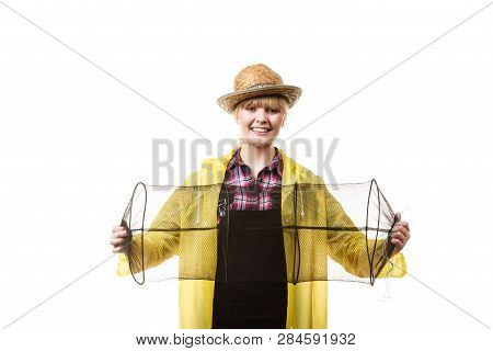 Spinning, Angling, Cheerful Fisherwoman Concept. Happy Woman In Yellow Raincoat Holding Empty Fishin