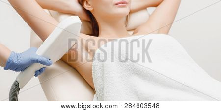 Woman Lying Couch In Beauty Salon Laser Hair Removal. Master With Gloves Performs Procedure Special 