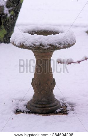 Frozen And Snow Covered Birdbath After A Winter Storm.