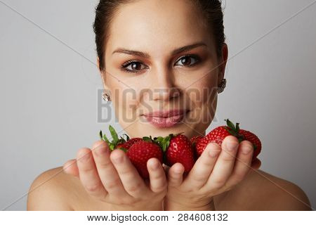 Pretty Happy Smiling Girl With Many Strawberry Over Colorful White Background.portrait Of Brunette C