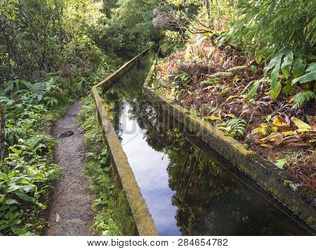 Footpath Along Lavada - Water Irrigation Canals Covered By Moss And Lush Vegetation On Hiking Trail 