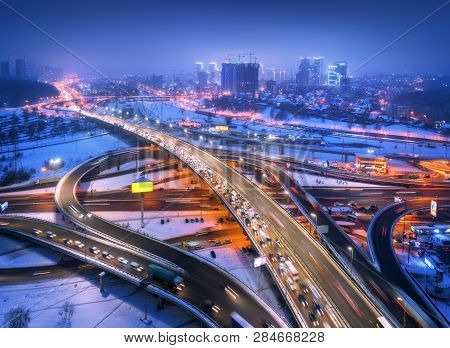 Aerial View Of The Road In Modern City At Night In Fog. Top View Of Traffic In Highway. Winter Citys
