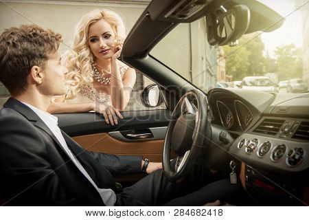 Beautiful Young Married Couple Sitting In Cabrio Car
