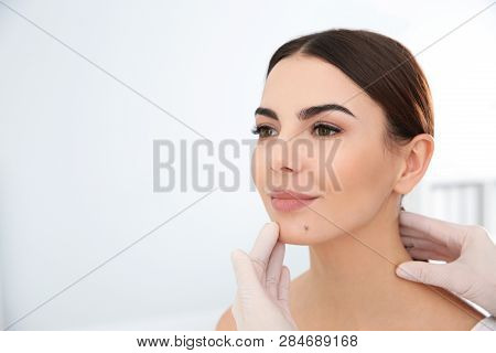 Dermatologist Examining Young Patient's Birthmark In Clinic. Space For Text