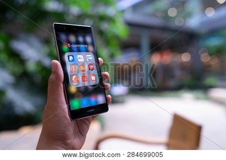 Chiang Mai, Thailand - May 05,2018: Man Holding Huawei With Icons Of E-commerce And Online Shopping 