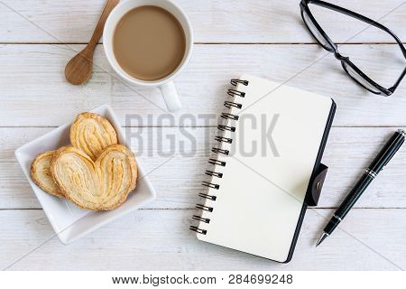 Cup Of Coffee With Snacks And Notebook On Desk Office With Copy Space, Top View