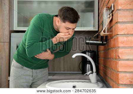 Young Man Having Nausea In Kitchen. Feeling Sick