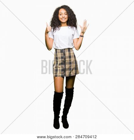 Young beautiful girl with curly hair wearing casual white t-shirt showing and pointing up with fingers number six while smiling confident and happy.