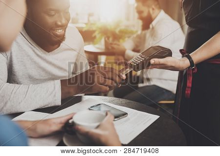 Young African American Is Calculated Credit Card. A Smiling African American Man Is Paying For An Or