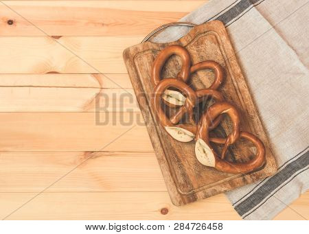 Freshy Baked Soft Pretzels On Wooden Cutting Board On Rustic Wooden Background. Toned Image. Top Vie