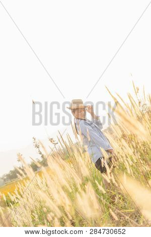 Girl Wearing A Hat Sitting Looking At Desho Grass.