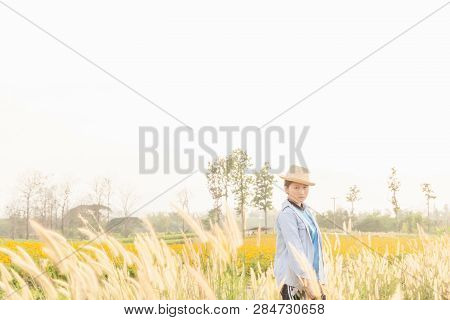 Girl Wearing A Hat Sitting Looking At Desho Grass.