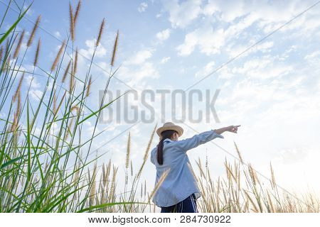 Girl Wearing A Hat Sitting Looking At Desho Grass.
