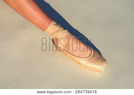 Toe Dancing. Ballerina Leg In White Ballet Shoe. Lacing Ballet Slipper. Female Foott In Pointe Shoe.