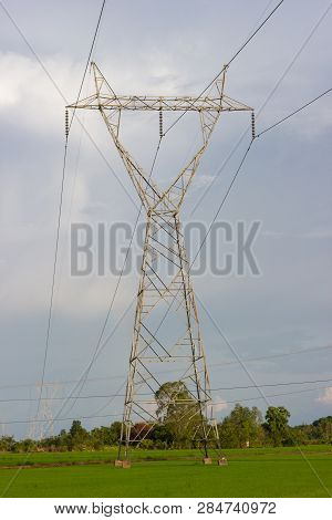 High Voltage Transmission Towers - Located In The Middle Of Green Rice Fields