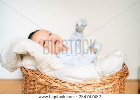 Infant Baby Lying On Blanket In Wood Baket On White Background