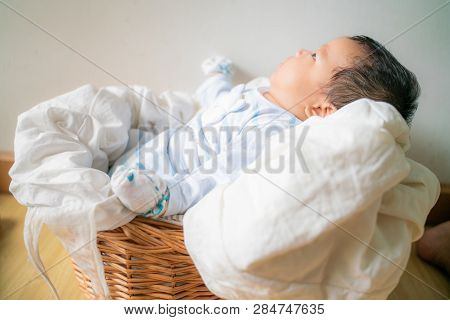 Infant Baby Lying On Blanket In Wood Baket On White Background