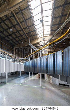 Powder Coating Line. Metal Panels Are Suspended On An Overhead Conveyor Line. Painting Products In A