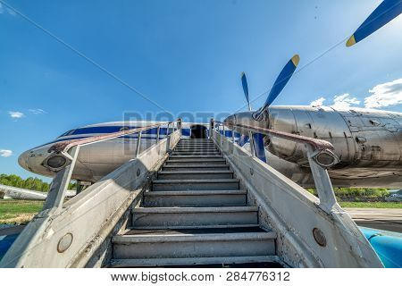 Old, Worn Passenger Gangway. Gangway Attached To The Aircraft.