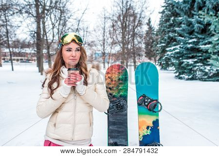 Beautiful Brunette Girl Winter Snowy Forest. In His Hand Mug Hot And Invigorating Coffee Tea, Warmin