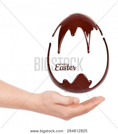 Chocolate egg in a hand. Melted chocolate syrup on a white background. Liquid chocolate on a white background.