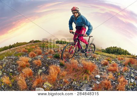 Placer Grass Similar To A Hedgehog With Rocks And Lichens On A Steep Slope, A Lone Rider Racer Rises