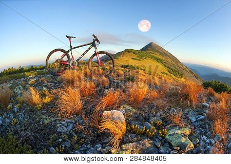 Placer Grass Similar To A Hedgehog With Rocks And Lichens On A Steep Slope, A Lone Rider Racer Rises