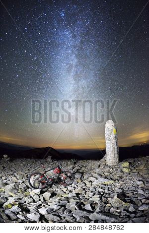 Placers With Stones On A Steep Peak With A Stone Pillar, A Mountain Professional Bicycle Against The