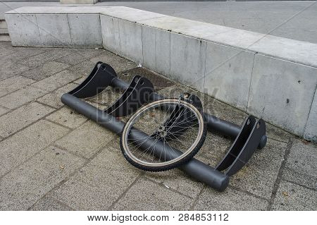 Bicycle Theft On The Street. Only Wheel With Chain Left On The Bicycle Parking