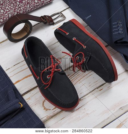 Male Loafers, Belt And Clothes On Wooden Background. Mens Shoes