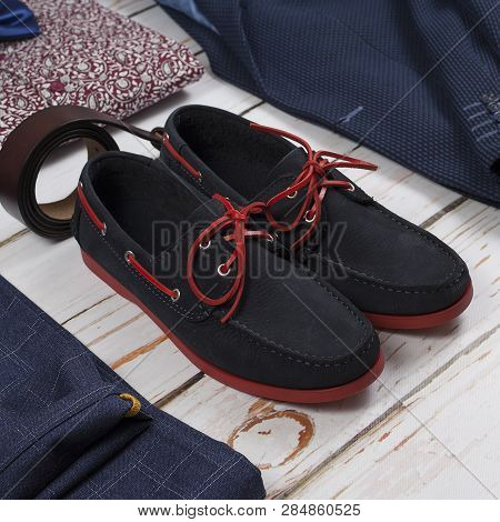 Male Loafers, Belt And Clothes On Wooden Background. Mens Shoes