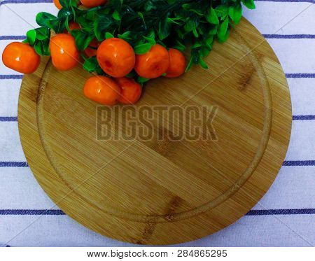 Red Round Berries, Fresh Ripe Juicy Orange Tangerines With Green Leaves, On A Round Wooden Board, Ho