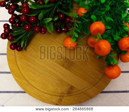 Red Round Berries, Fresh Ripe Juicy Orange Tangerines With Green Leaves, On A Round Wooden Board, Ho
