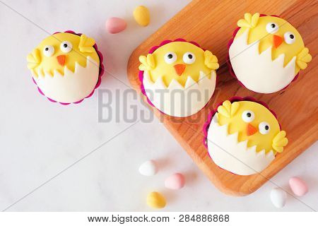 Hatching Spring Chick Cupcakes On A Wood Serving Platter. Flay Lay Against A White Marble Background