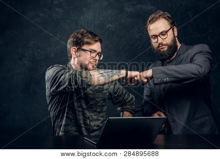 Friendship, Brofist, Cooperation. Two Programmers Colleagues Fist Bumping After Completion Of The Ge