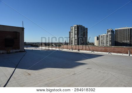 Flat Open Roof On The Top Of An Apartment Building Under A Clear Blue Sky