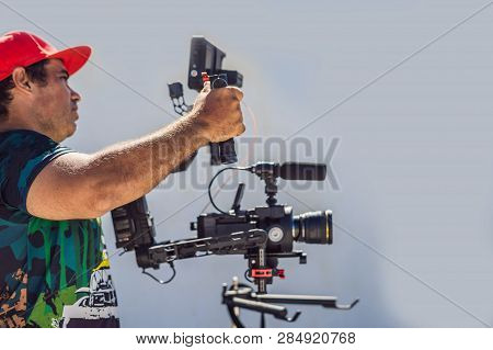 Steadicam Operator And His Assistant Prepare Camera And 3-axis Stabilizer-gimbal For A Commercial Sh