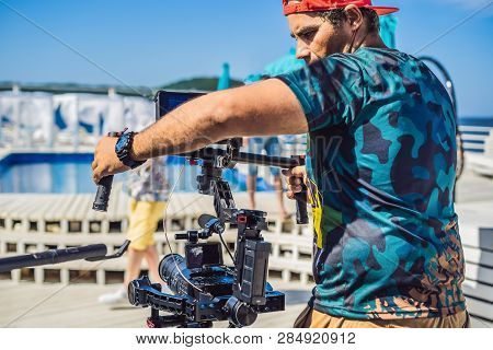 Steadicam Operator And His Assistant Prepare Camera And 3-axis Stabilizer-gimbal For A Commercial Sh