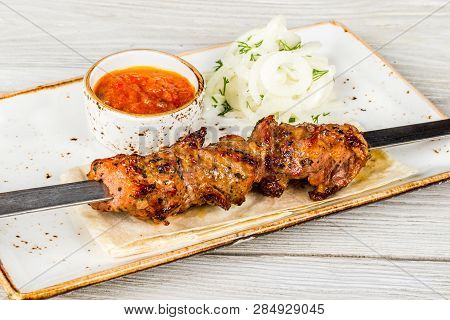 Skewers, Onions, Pita Bread, Sauce On A White Plate