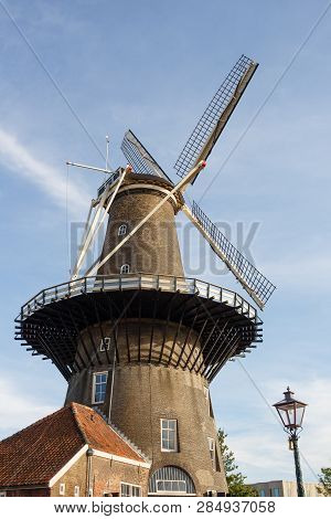 Molen De Valk Windmill At Leiden, Netherlands. Sunny Day And Sky With Clouds.