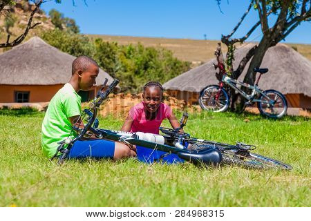 African Children Fixing A Puncture On A Bike