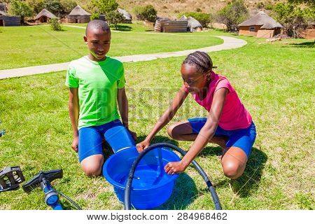 African Children Fixing A Puncture On A Bike
