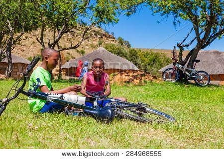 African Children Fixing A Puncture On A Bike