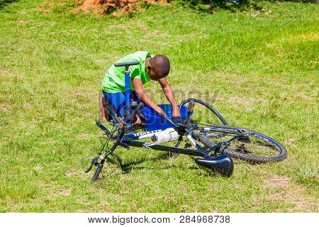 African Children Fixing A Puncture On A Bike