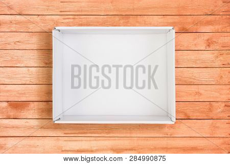 White Open Box On Coral Wooden Background. Flat Lay