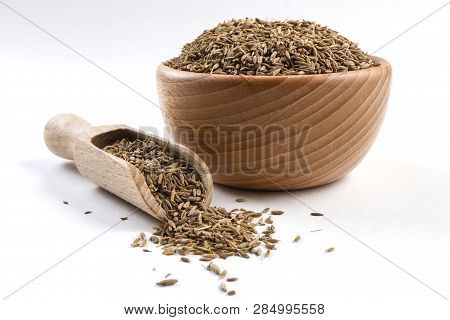 Cumin In Wooden Bowl And Scoop Isolated On White Background. Closeup.