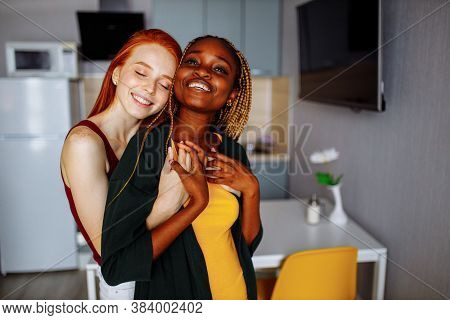 Cheerful Afro And European Lesbian Women At Home On The Bed
