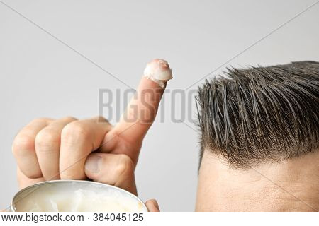 Man Applying A Clay, Pomade, Wax, Gel Or Mousse From Round Metal Box For Styling His Hair After Barb