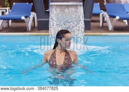 Beautiful Brunette Woman In Bikini Enjoying Relaxing In Swimming Pool, Looking Aside With Confident 