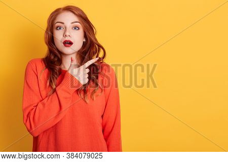 Bugged Eyed Beautiful Red Haired Woman Looks With Astonished Expression As Advertises Something Unus